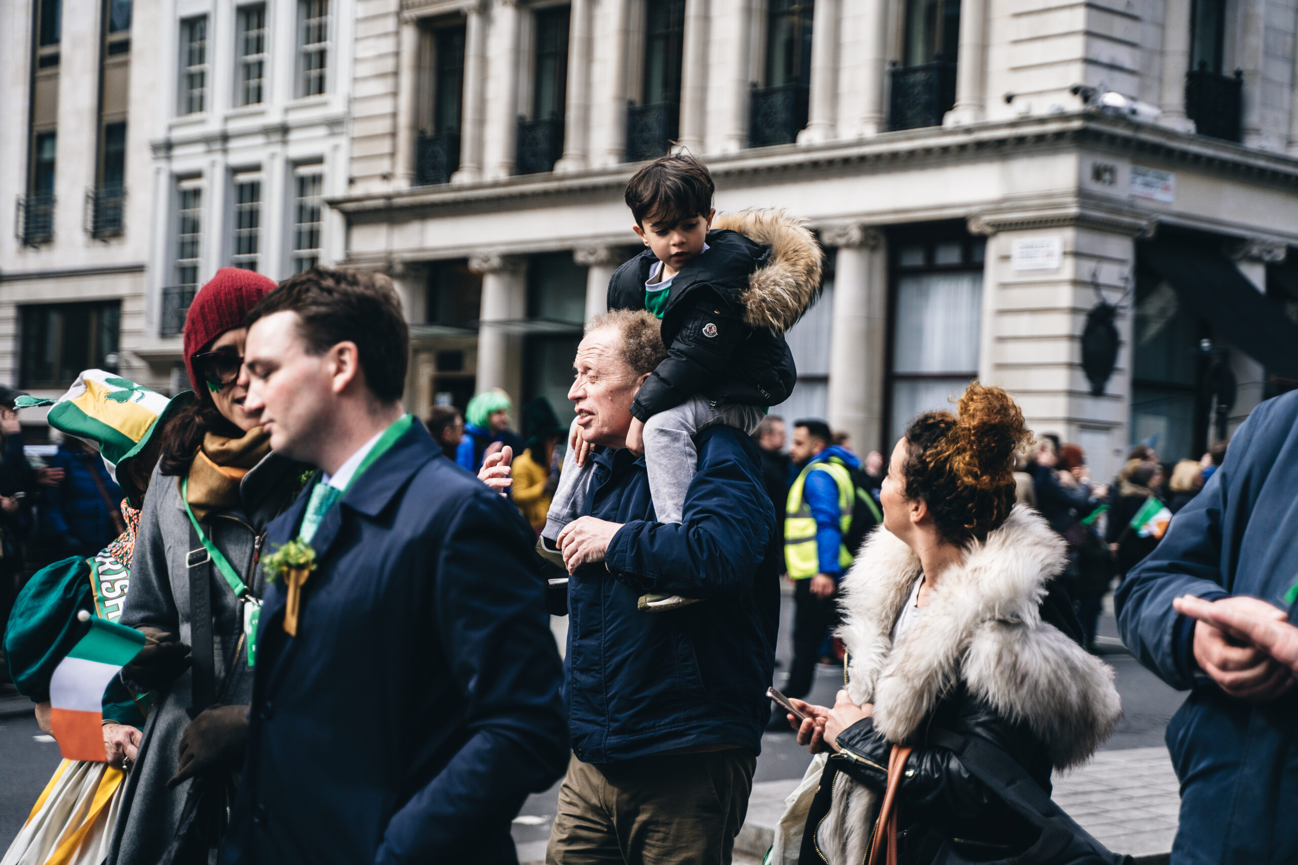 Man with a kid on a shoulders at St. Patrick Day