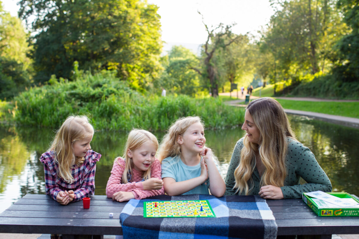 3 girls and woman playing a board game